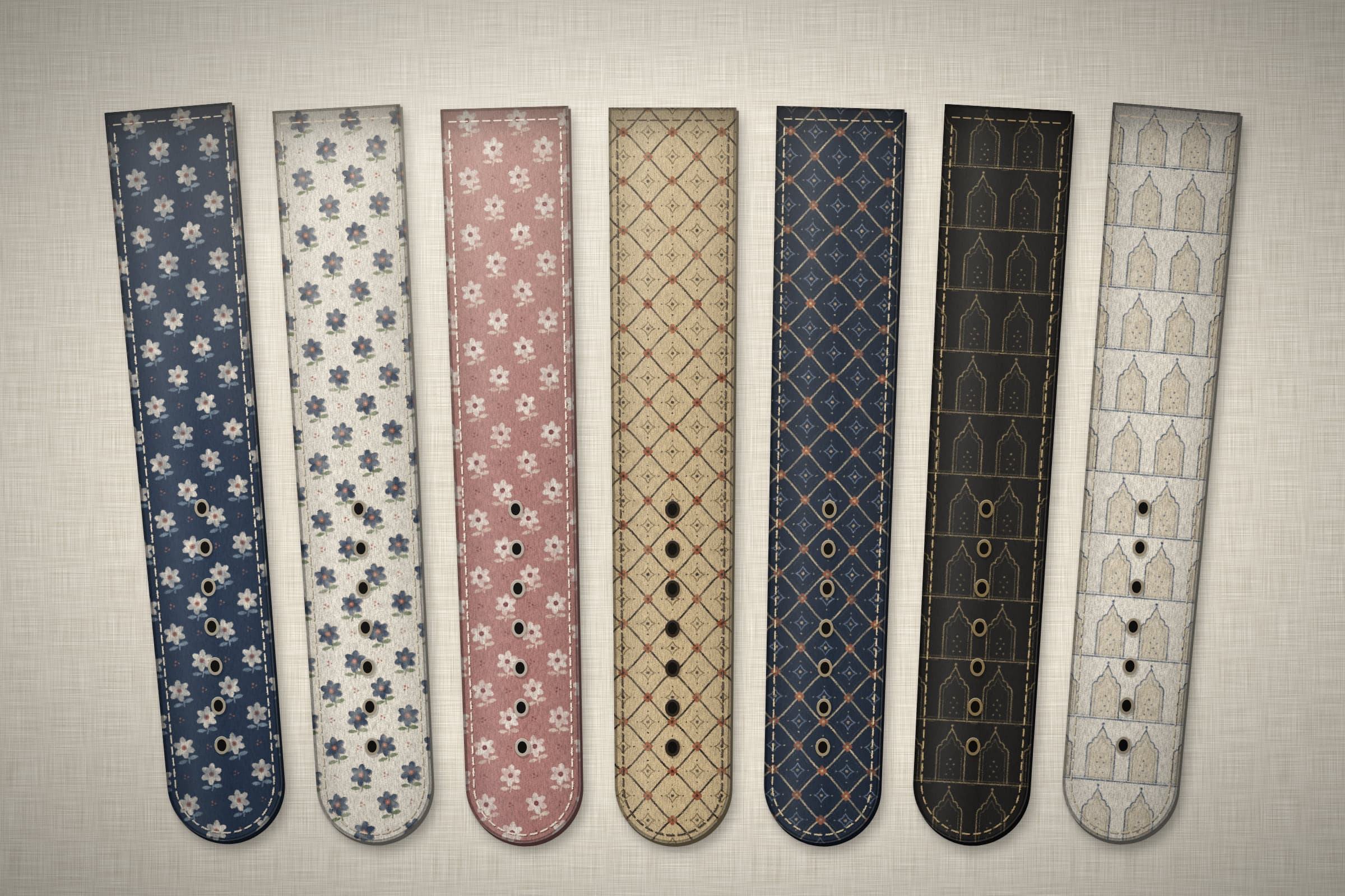 Concept render: seven printed straps laid side by side on linen.